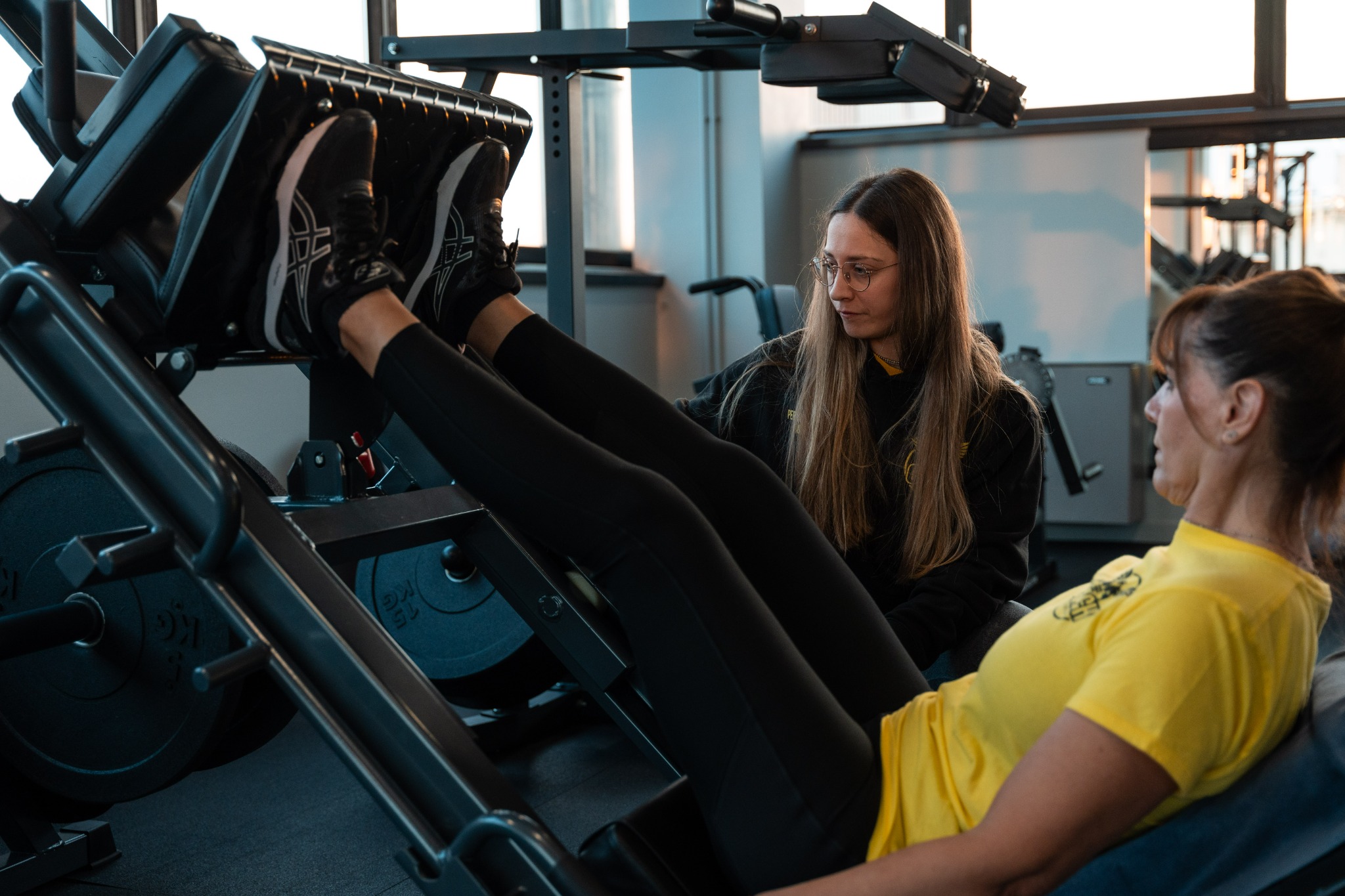 Personal trainer che segue una cliente durante l’allenamento